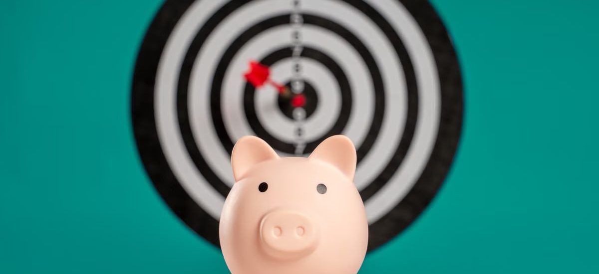 Piggy bank with bullseye dart board symbolizing financial goals and savings.