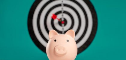 Piggy bank with bullseye dart board symbolizing financial goals and savings.
