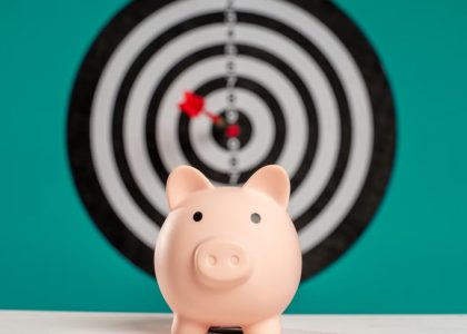 Piggy bank with bullseye dart board symbolizing financial goals and savings.